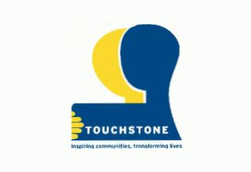 Touchstone logo showing two silhouetted heads, one is blue the other is yellow. The writing underneath the word Touchstone reads 'Inspiring communities, transforming lives.'