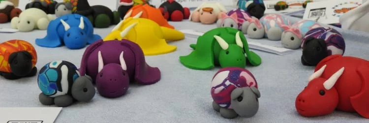 Image shows a stall which has numerous plasticine dragons on it.